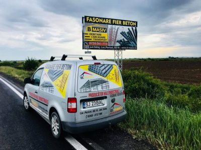 Panou publicitar de tip Unisign lângă șosea