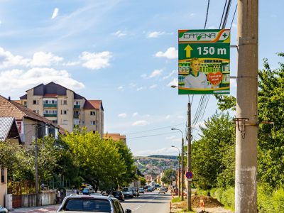Panou direcțional amplasat pe stâlpul de illuminat public.