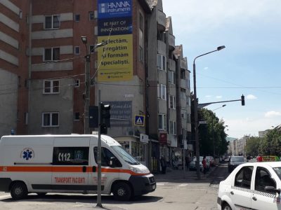 Panou publicitar de tip mesh amplasat pe clădire în oraș